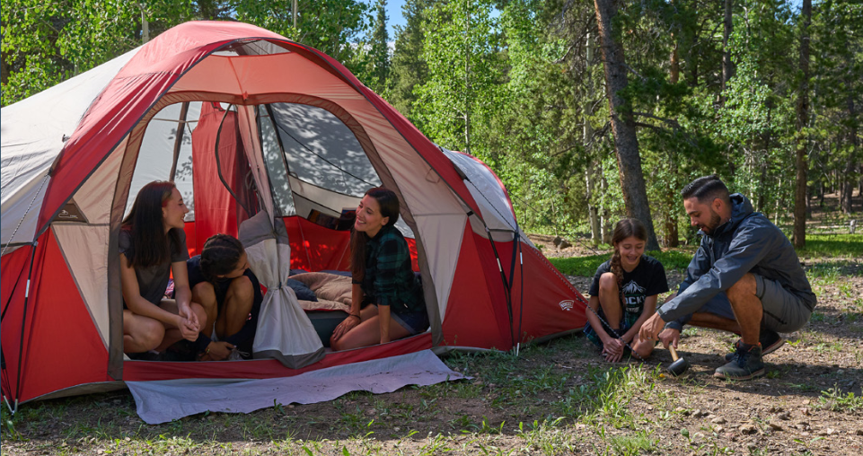 Mom and two daughters in tent while dad and son are out of it in the outdoors