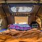 Interior of Vagabond XL Rooftop Tent with sheets, lights, and skylight