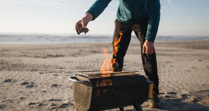 BioLite firePit+ on beach with man behind it