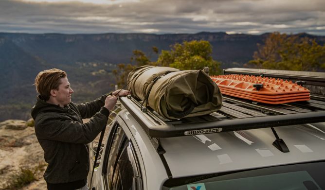 rhino rack guy loading up gear on a mountain top 