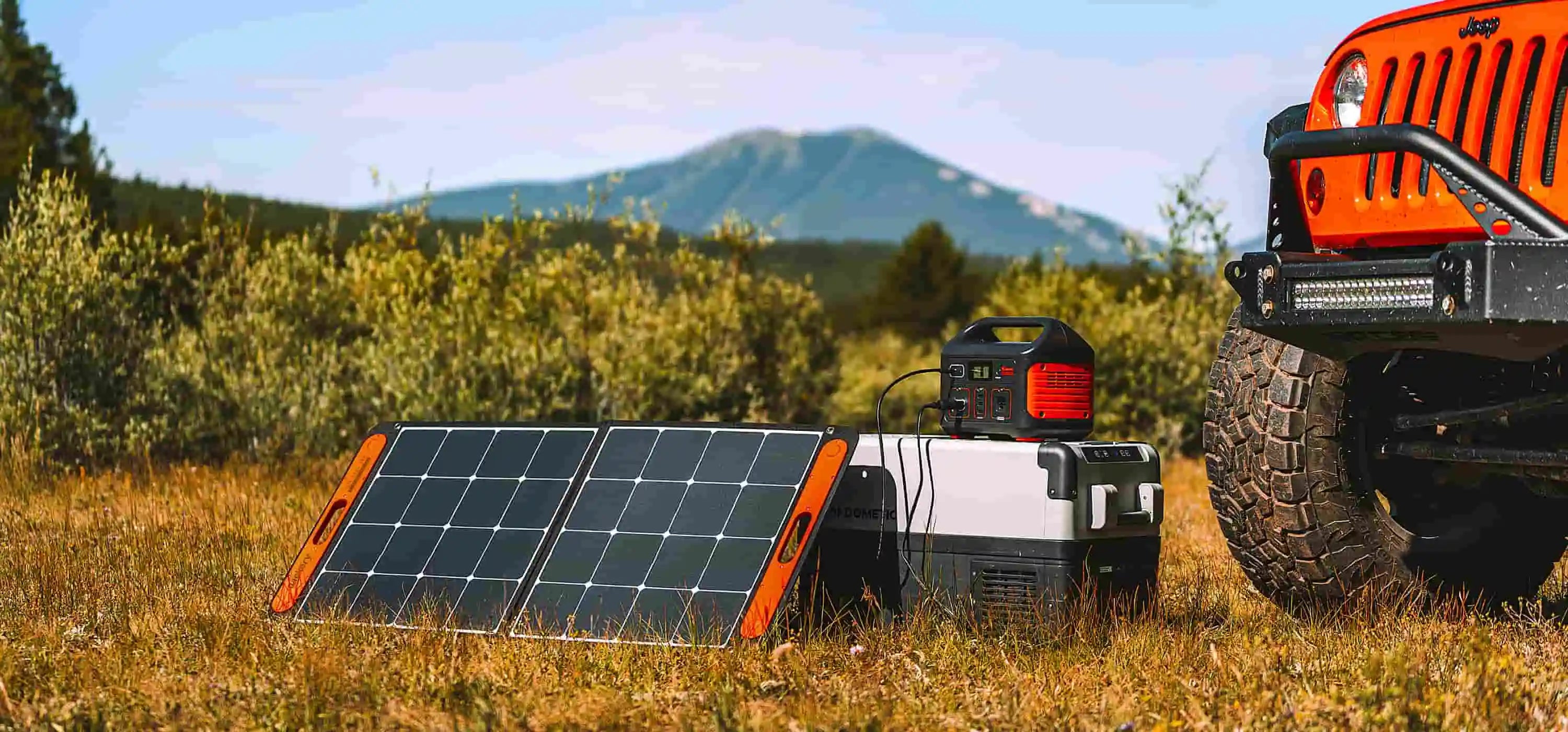 Jackery Solar panel with Generator  in clearing with mountain in the  back and front of jeep.